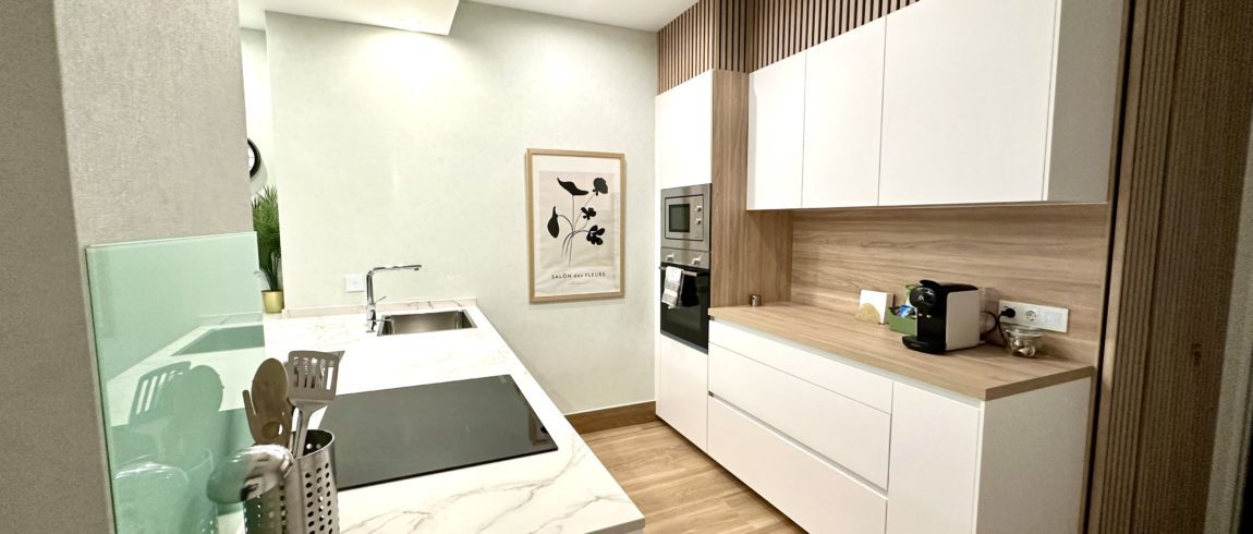 Cocina moderna con encimeras blancas y diseño minimalista.