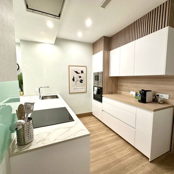 Cocina moderna con encimeras blancas y diseño minimalista.