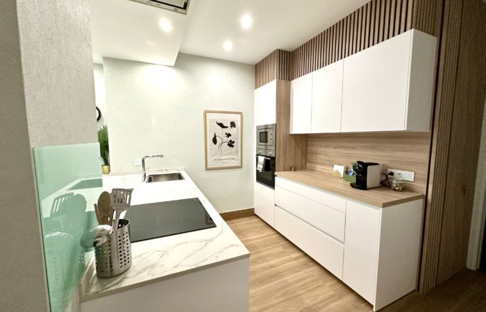 Cocina moderna con encimeras blancas y diseño minimalista.