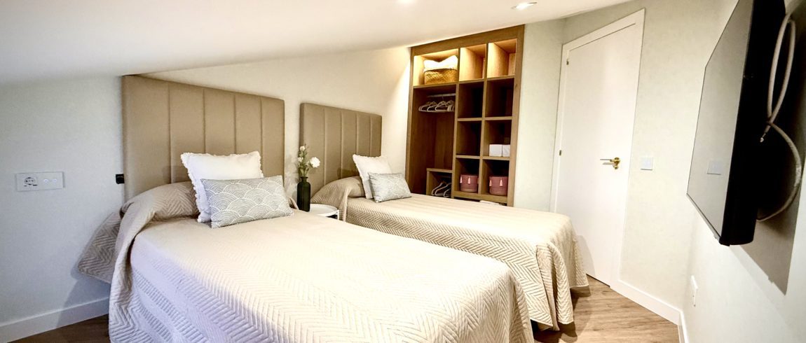 Habitación moderna con dos camas y decoración acogedora.