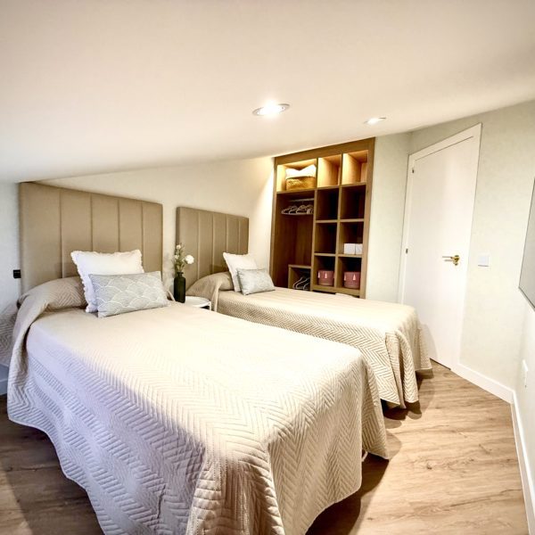 Habitación moderna con dos camas y decoración acogedora.