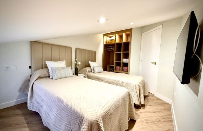 Habitación moderna con dos camas y decoración acogedora.