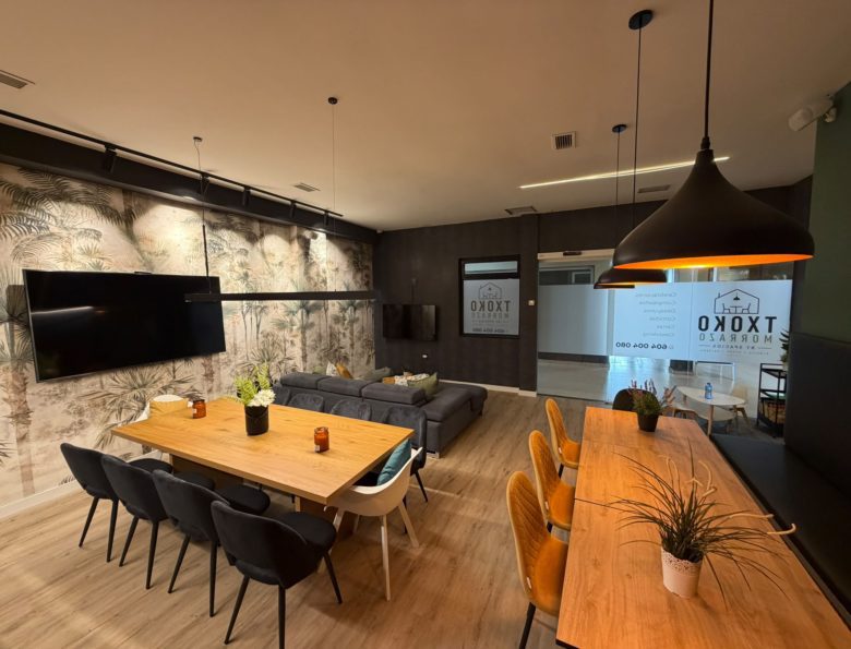 Comedor del Txoko Morrazo con mesas largas y televisión de gran formato